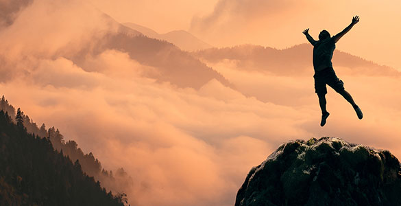 Man jumping in victory with a beautiful sunset background