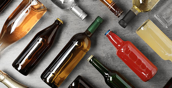 Various bottles of alcohol laid down on a grey background