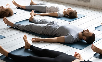 Focus on man laying in a yoga class