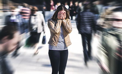 Woman being emotionally overwhelmed in a crowd of people