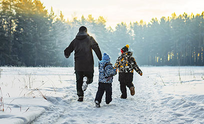 Man and his children run in the snow