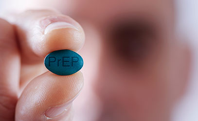 Man blurred in the background holding a blue pill with the letters PREP on it
