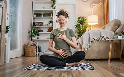 Woman seated on the floor doing diaphragmatic breathing