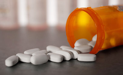 Three white capsule pills on a white background