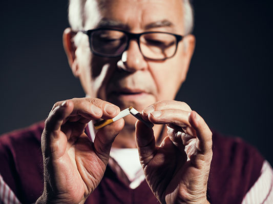 Man snaps a cigarette in two.