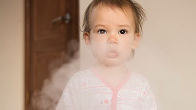 Young girl is standing in a cloud of cigarette smoke