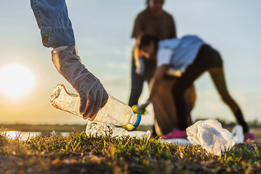 People picking up trash near a beach