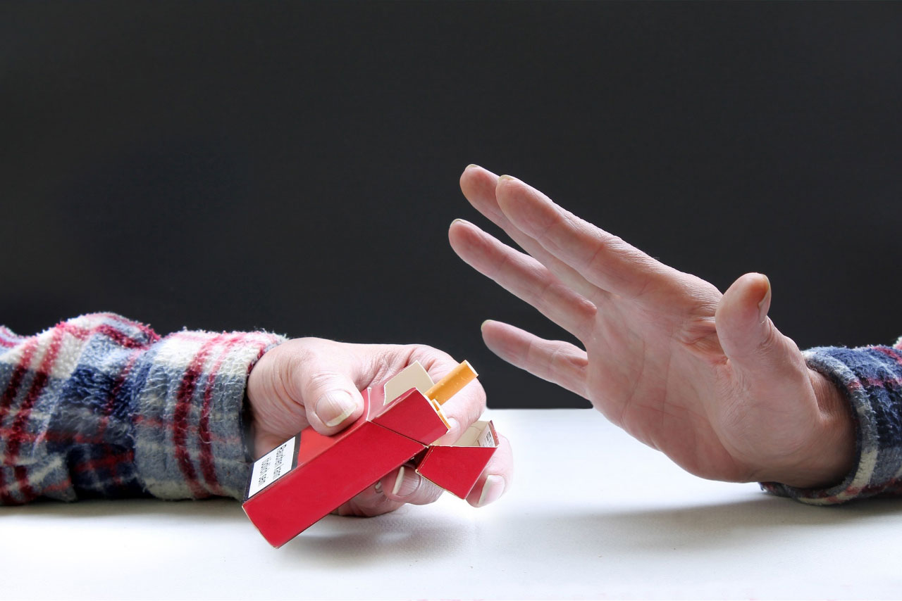 Photo of hands, one is offering a cigarette, the other is rejecting it