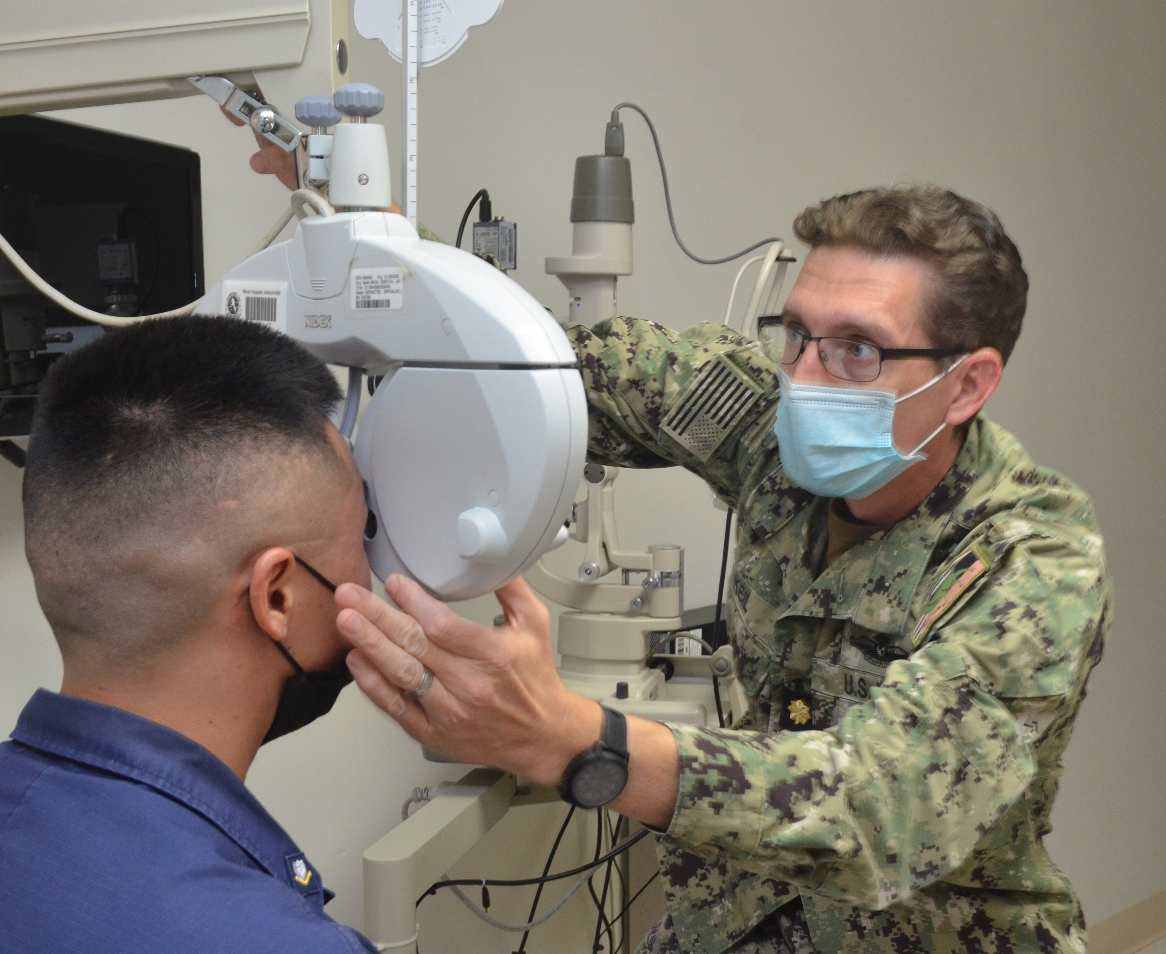 KEY WEST, Fla. (Sept. 14, 2021) - Lt. Cmdr. Joshua Keil, an optometrist at Naval Branch Health Clinic Key West, performs an eye exam on U.S. Coast Guard Petty Officer 3rd Class Thomas Li. Keil is a native of Palmer, Alaska and holds a doctor of optometry from University of Missouri. He says, "If we find signs of eye disease early, we can treat it before it gets worse. That's why everyone needs eye exams, not just those who wear glasses. It's really about the long-term health of your eyes." (U.S. Navy photo by Deidre Smith, Naval Hospital Jacksonville/Released).